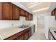 Kitchen with double sink and wooden cabinets at 9425 Blind Pass Rd # 1008, St Pete Beach, FL 33706