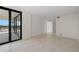 Bright living room featuring tile floors, a balcony with city views, and neutral walls, creating a versatile space at 9425 Blind Pass Rd # 1008, St Pete Beach, FL 33706