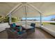 Covered outdoor patio with table, chairs, bench seating and beautiful water view at 9425 Blind Pass Rd # 1008, St Pete Beach, FL 33706