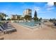 Community pool area featuring a large swimming pool, lounge chairs, and beautiful waterfront views at 9425 Blind Pass Rd # 1008, St Pete Beach, FL 33706