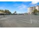 On-site tennis court offers a recreational amenity surrounded by palm trees and blue sky at 9425 Blind Pass Rd # 1008, St Pete Beach, FL 33706