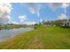 Expansive backyard featuring a serene pond and well-maintained green lawn, ideal for outdoor activities at 1012 Radison Lake Ct # 59, Sun City Center, FL 33573