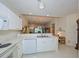 Well-lit kitchen with white cabinetry and modern appliances, open to a cozy living space at 1012 Radison Lake Ct # 59, Sun City Center, FL 33573