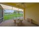 Inviting lanai featuring comfortable seating and serene views of the lush green lawn and pond at 1012 Radison Lake Ct # 59, Sun City Center, FL 33573