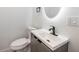 Contemporary bathroom with a gray vanity, illuminated mirror, and a stylish faucet at 109 Magnolia Ave, Seffner, FL 33584