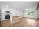 Bright open floor plan with modern kitchen with stainless appliances and wood flooring at 109 Magnolia Ave, Seffner, FL 33584