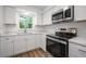 Bright kitchen featuring stainless steel appliances and stone countertops at 109 Magnolia Ave, Seffner, FL 33584