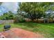 Expansive backyard featuring mature trees, lush lawn, brick patio, and convenient storage shed at 117 Connie Ave, Tampa, FL 33613