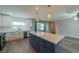 Bright kitchen with an island, white cabinets, stainless steel appliances, and wood-look floors at 117 Connie Ave, Tampa, FL 33613