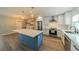 Renovated kitchen with white cabinets, quartz countertops, stainless steel appliances, and a blue island at 117 Connie Ave, Tampa, FL 33613