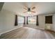 Cozy living room with wood floors, ceiling fan, large window, and backyard access at 117 Connie Ave, Tampa, FL 33613