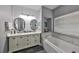Beautiful bathroom featuring a double vanity, oval mirrors, and a relaxing soaking tub with natural light at 11806 Holly Crest Ln, Riverview, FL 33569