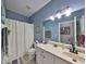 Bathroom with blue walls, vanity and a shower tub combination at 11806 Holly Crest Ln, Riverview, FL 33569