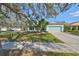 Charming single-story home featuring a well-manicured lawn, mature trees, and a two-car garage at 11806 Holly Crest Ln, Riverview, FL 33569
