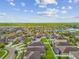 Expansive aerial shot of a residential community with a serene lake and lush green surroundings at 11837 Thicket Wood Dr, Riverview, FL 33579