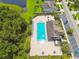 Aerial view of a sparkling community pool, surrounded by lush greenery and a convenient parking area at 11837 Thicket Wood Dr, Riverview, FL 33579