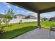 The backyard features a white fence, green grass and a covered patio at 11837 Thicket Wood Dr, Riverview, FL 33579