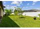 The backyard has green grass, landscaping and a white fence at 11837 Thicket Wood Dr, Riverview, FL 33579