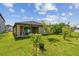 Exterior of home and patio, view of backyard with green grass and plants at 11837 Thicket Wood Dr, Riverview, FL 33579