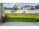 View of the green backyard that features a white fence at 11837 Thicket Wood Dr, Riverview, FL 33579