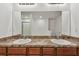 This bathroom features double sinks, granite countertops, wood cabinets, and a large mirror at 11837 Thicket Wood Dr, Riverview, FL 33579