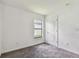 A carpeted bedroom with a window view to the outside, and a closet door at 11837 Thicket Wood Dr, Riverview, FL 33579