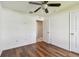 Bedroom with hardwood floors, ceiling fan, and two doors in a well-lit area at 11837 Thicket Wood Dr, Riverview, FL 33579