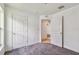 A bright bedroom featuring gray carpet and white walls and doors at 11837 Thicket Wood Dr, Riverview, FL 33579