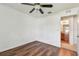 Bedroom with wood-look floors, ceiling fan, and view into adjacent bathroom at 11837 Thicket Wood Dr, Riverview, FL 33579