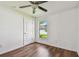Cozy bedroom featuring a ceiling fan, window with outdoor views, and a white door at 11837 Thicket Wood Dr, Riverview, FL 33579