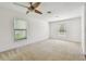 Spacious bedroom featuring neutral carpet, a ceiling fan, and bright windows at 11837 Thicket Wood Dr, Riverview, FL 33579