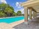 Inviting community pool area with covered patio seating and surrounding tropical greenery at 11837 Thicket Wood Dr, Riverview, FL 33579