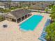 Aerial view of a large, pristine community pool with lounge chairs and a covered pavilion at 11837 Thicket Wood Dr, Riverview, FL 33579