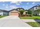 Well-maintained home with a two-car garage, manicured lawn, and colorful landscaping at 11837 Thicket Wood Dr, Riverview, FL 33579