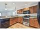 Well-lit kitchen featuring stainless steel appliances, wood cabinets, and granite countertops at 11837 Thicket Wood Dr, Riverview, FL 33579