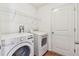 The laundry room has a modern washer, dryer and wire shelving at 11837 Thicket Wood Dr, Riverview, FL 33579