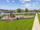 Well-maintained community playground, featuring play equipment and benches, set in a green space at 11837 Thicket Wood Dr, Riverview, FL 33579