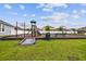 Community playground with slides, climbing structures, and swings, set against a blue sky backdrop at 11837 Thicket Wood Dr, Riverview, FL 33579