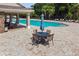 Relaxing pool area with umbrella-shaded tables, perfect for enjoying sunny days and refreshing swims at 11837 Thicket Wood Dr, Riverview, FL 33579