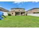 Large backyard with lush green grass, white fencing, patio, and playset, perfect for outdoor enjoyment at 12316 Streambed Dr, Riverview, FL 33579