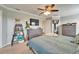 Bright primary bedroom with a king bed, ceiling fan, and a partial view into the bathroom at 12316 Streambed Dr, Riverview, FL 33579