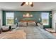 Spacious primary bedroom with a king bed, ceiling fan, and two large windows at 12316 Streambed Dr, Riverview, FL 33579