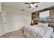 This bedroom has a ceiling fan, a wood accent wall, and neutral carpet at 12316 Streambed Dr, Riverview, FL 33579