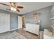 This bedroom has grey walls, an open doorway, and wood-look floors at 12316 Streambed Dr, Riverview, FL 33579