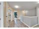 Bright hallway with neutral paint, hardwood floors, and an opening to a bedroom at 12316 Streambed Dr, Riverview, FL 33579