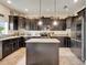 Traditional kitchen with dark cabinets, stainless steel appliances, granite countertops, and a kitchen island at 12316 Streambed Dr, Riverview, FL 33579