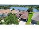 Aerial view of home with brown roof, screened-in lanai, and large lake view at 13910 Chalk Hill Pl, Riverview, FL 33579