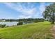 Expansive backyard with lush green grass and stunning waterfront views of the lake at 13910 Chalk Hill Pl, Riverview, FL 33579