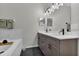 Elegant bathroom featuring a dual vanity with grey cabinetry, white countertop, modern fixtures and soaking tub at 13910 Chalk Hill Pl, Riverview, FL 33579
