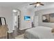 Spacious bedroom with gray toned walls, dark wood floors, king bed and TV on wall at 13910 Chalk Hill Pl, Riverview, FL 33579